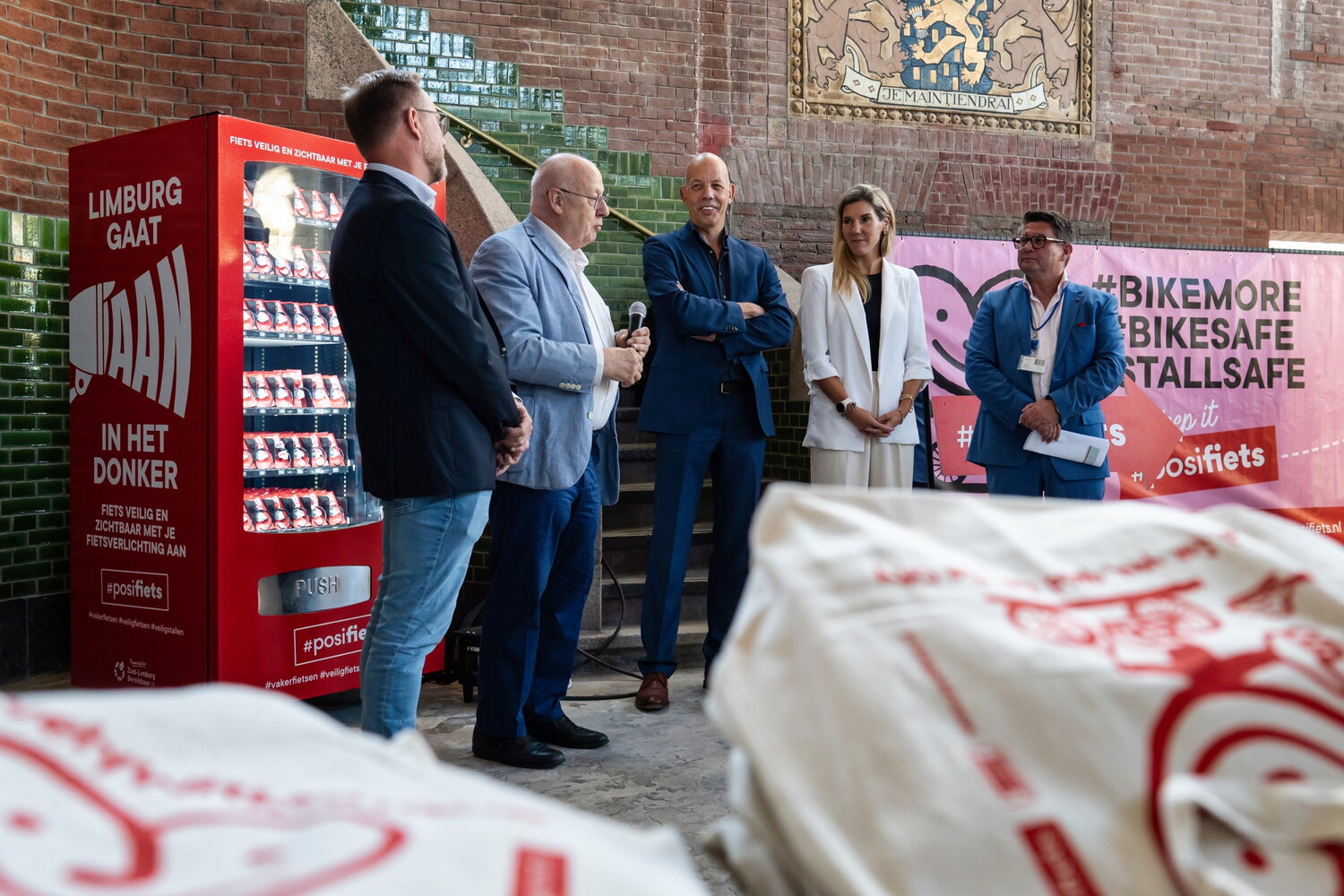 sprekers staan voor banner van posifiets en lampjesautomaat 