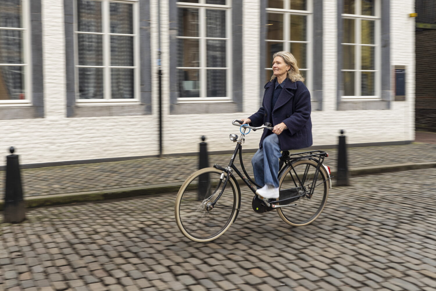 vrouw fietsend met een wit gebouw op de achtergrond