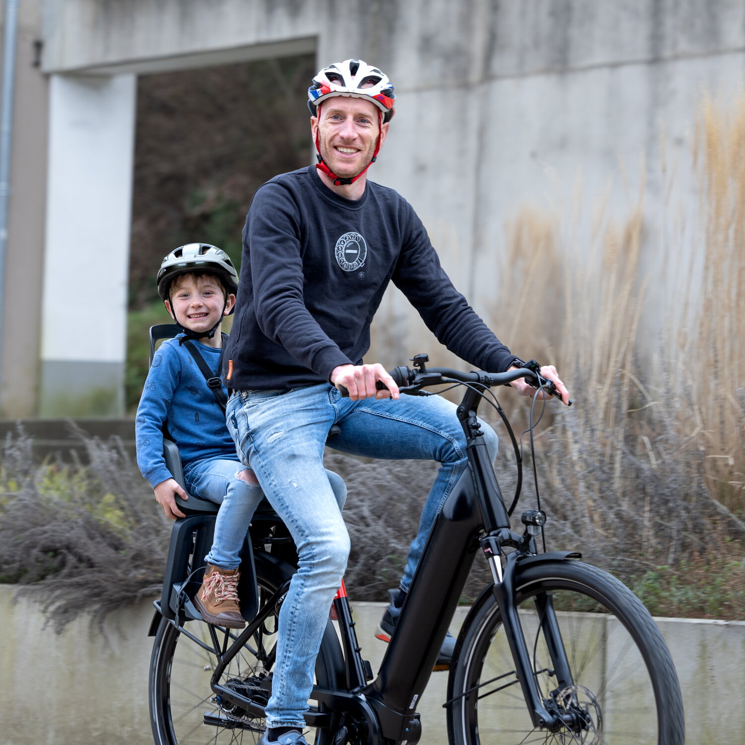 Marcel Aries - neuroloog bij het MUMC+ - met zijn zoon op de fiets. Ze dragen allebei een helm.