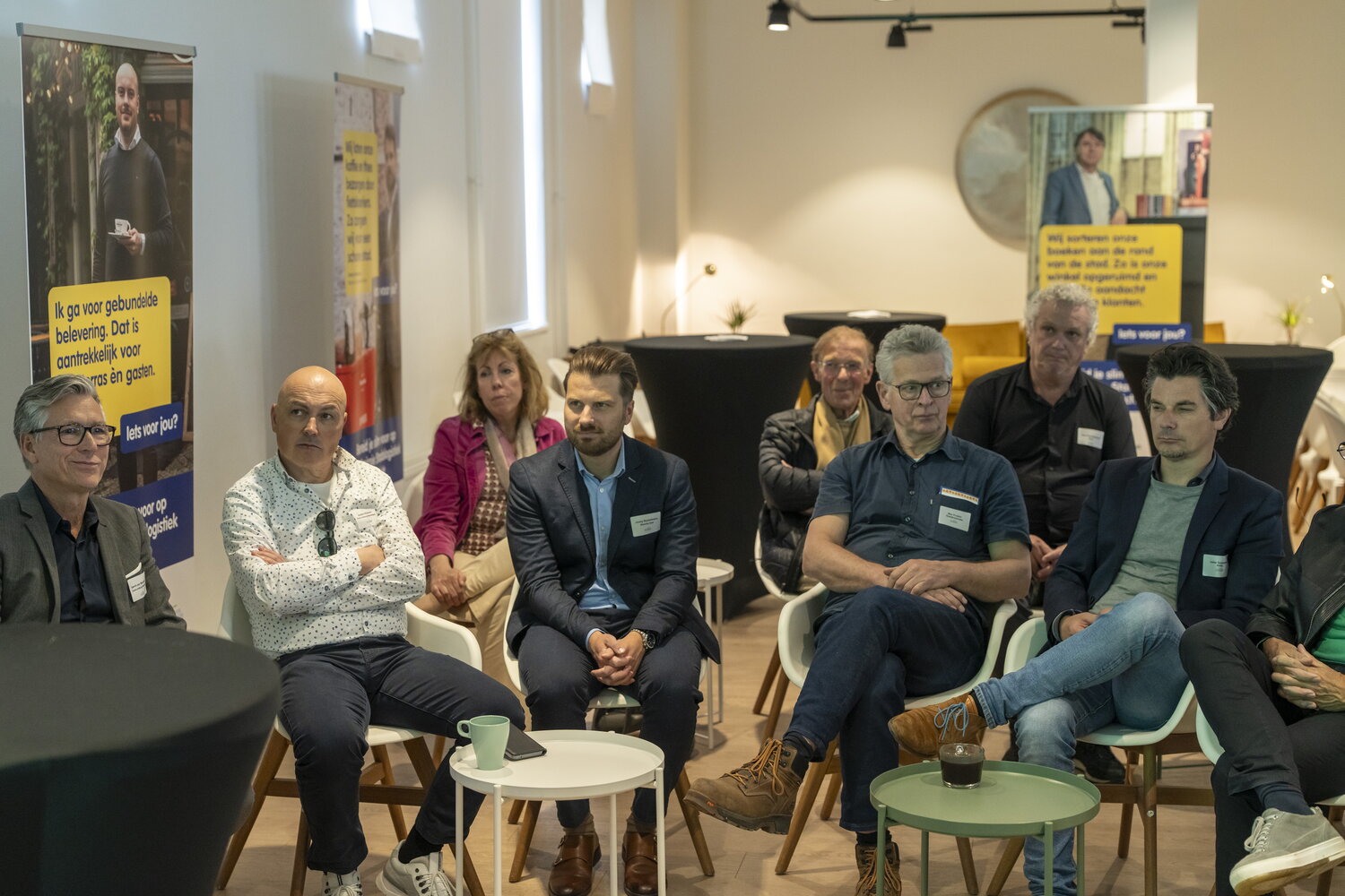 Een groep mensen zit te luisteren naar een spreker