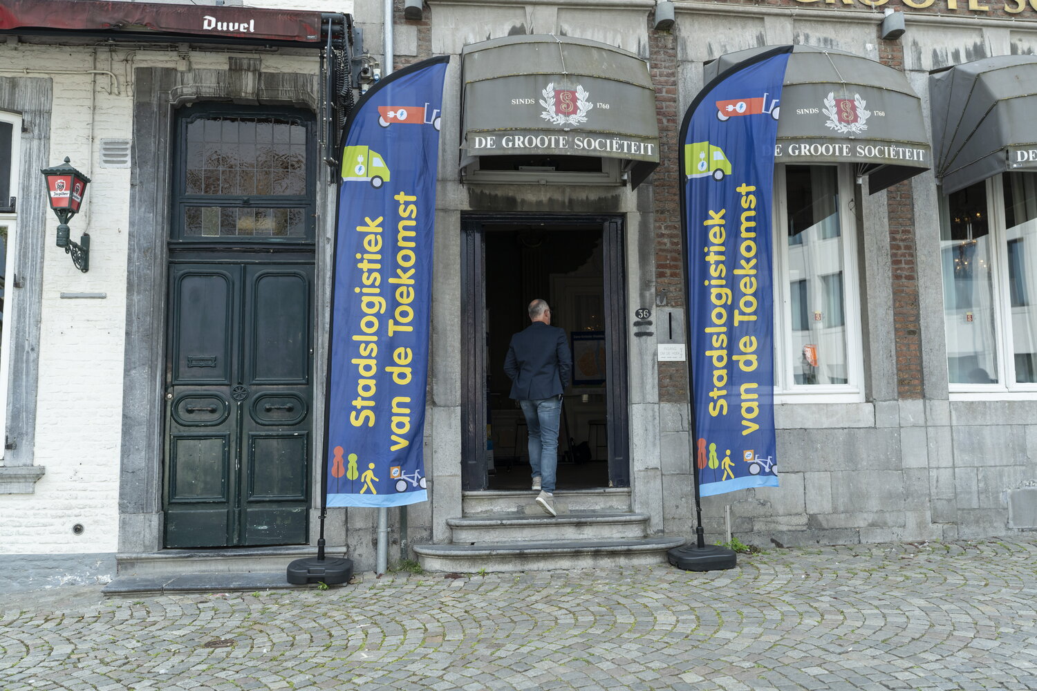 Ingang van de Groote Sociëteit in Maastricht met blauwe banners ervoor van Stadslogistiek van de Toekomst