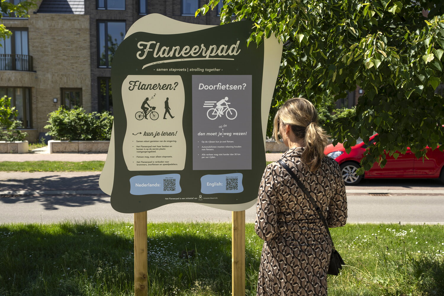 Vrouw kijkt naar een bord waar de etiquette van het Flaneerpad op staan
