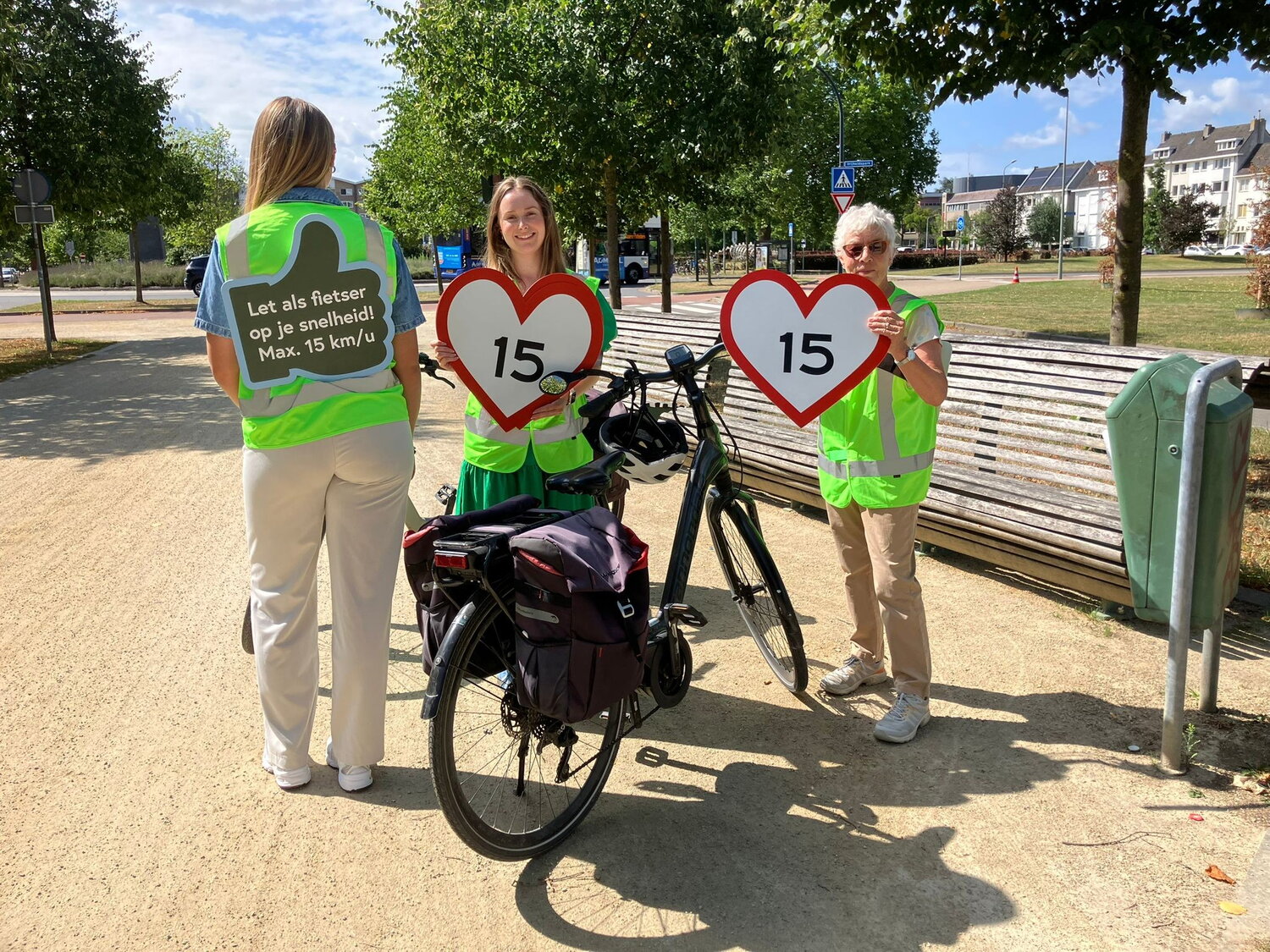Groene Loper zomeractie 2025 - fietsers niet te snel, mensen houden bordjes omhoog met gewenste snelheid