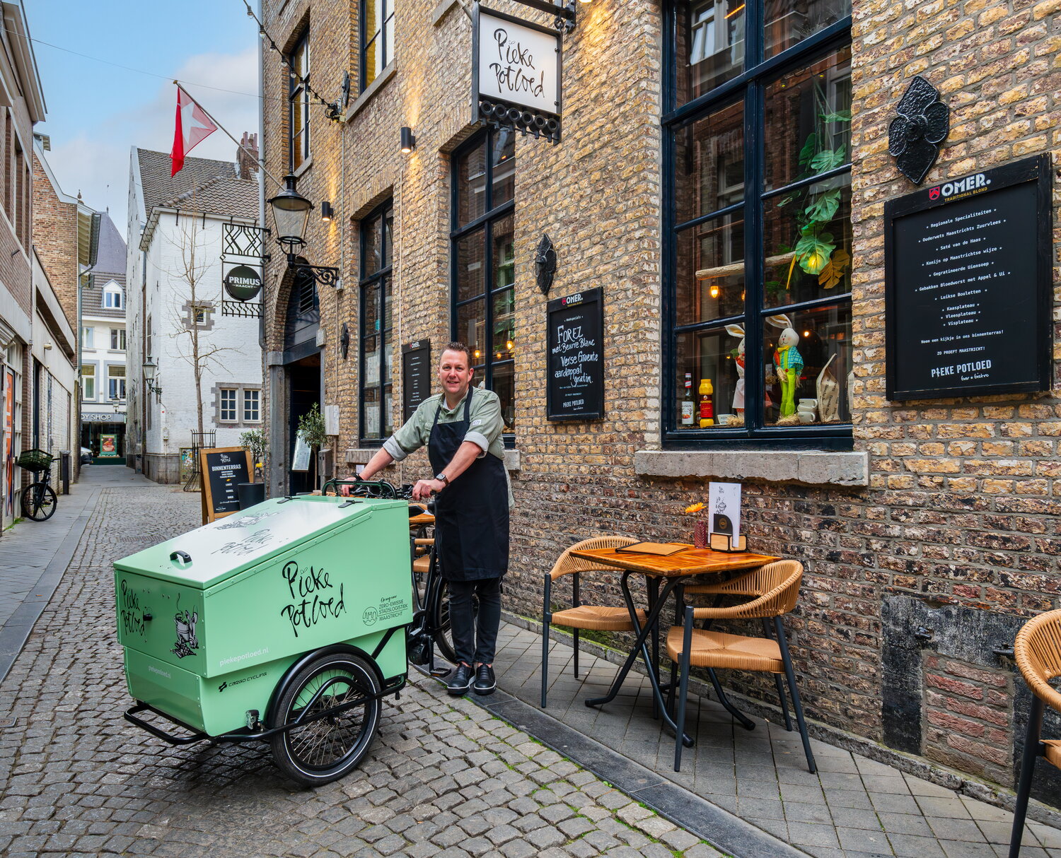 Eigenaar restaurant met bakfiets voor zijn zaak