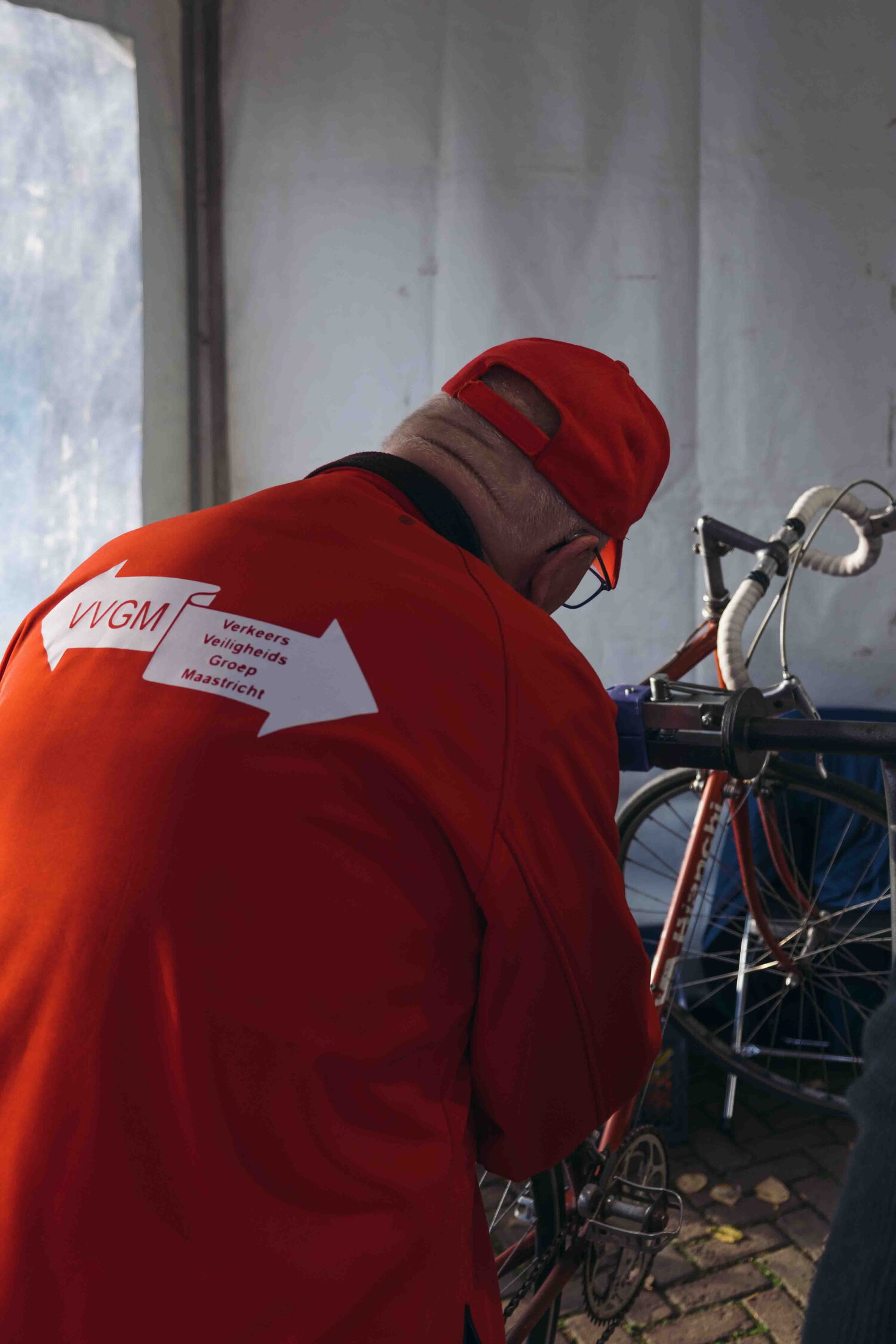 vrijwilliger van VVGM die een fiets repareert