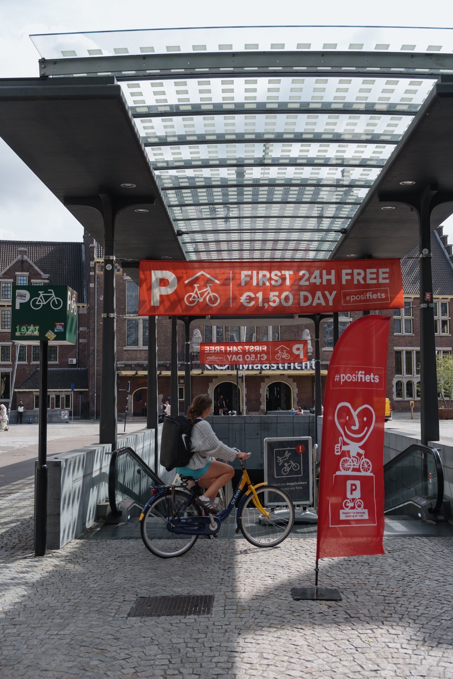 foto van de ingang van de stalling bij station maastricht met posifiets vlaggen
